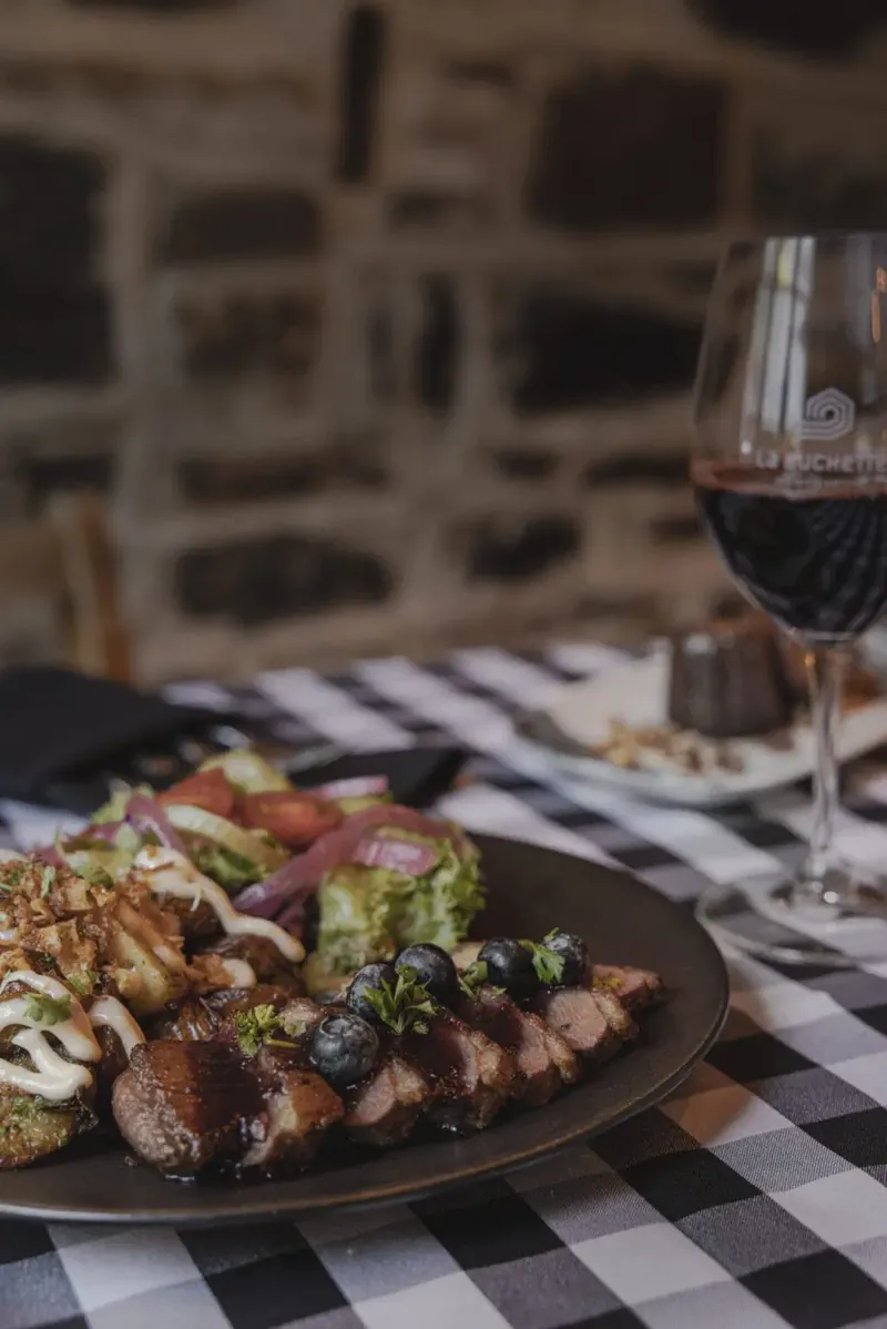 Magret de canard grillé, sauce aux bleuets et au miel, et cannelés à La Buchette